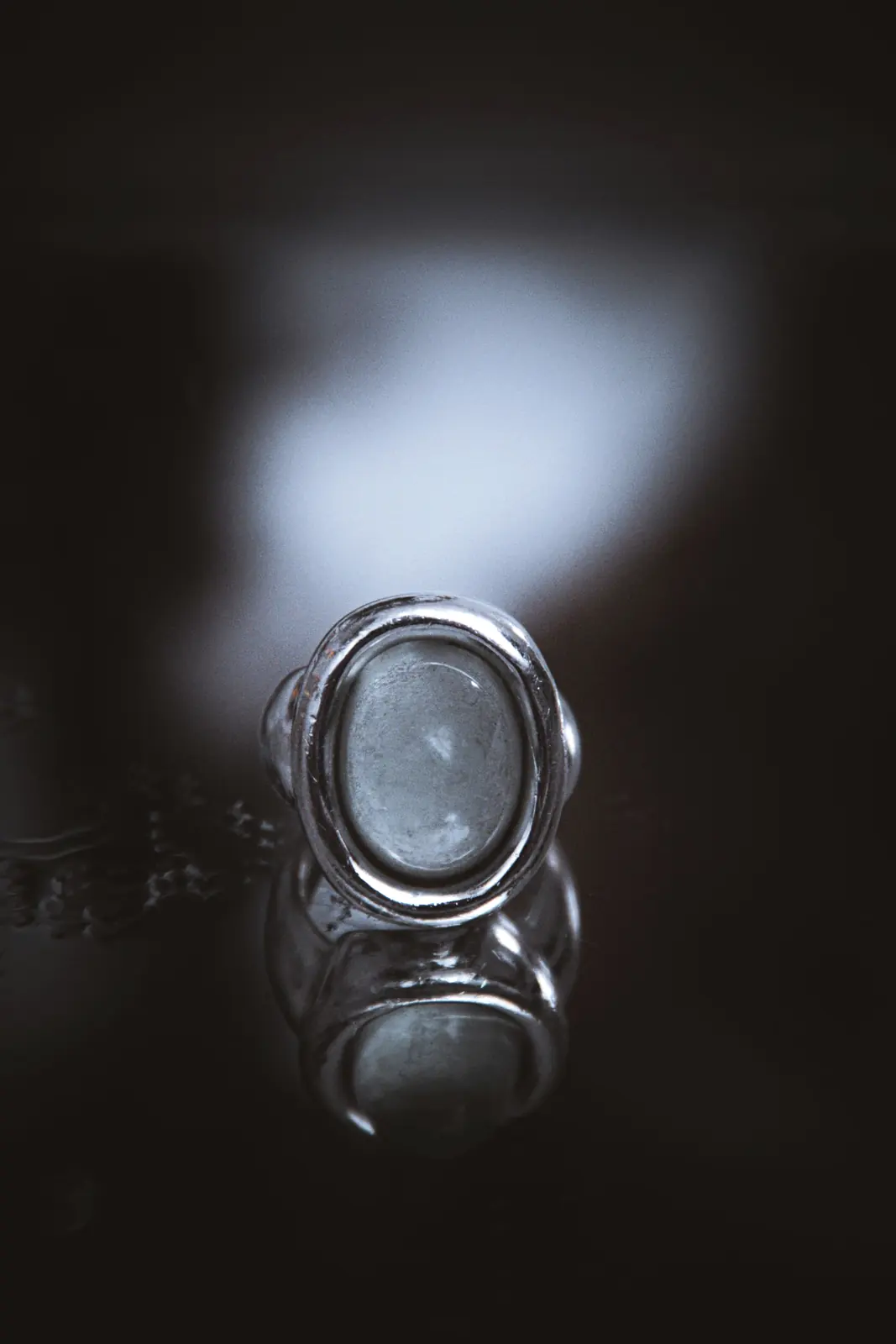 Anillo de plata con una piedra y luz detrás