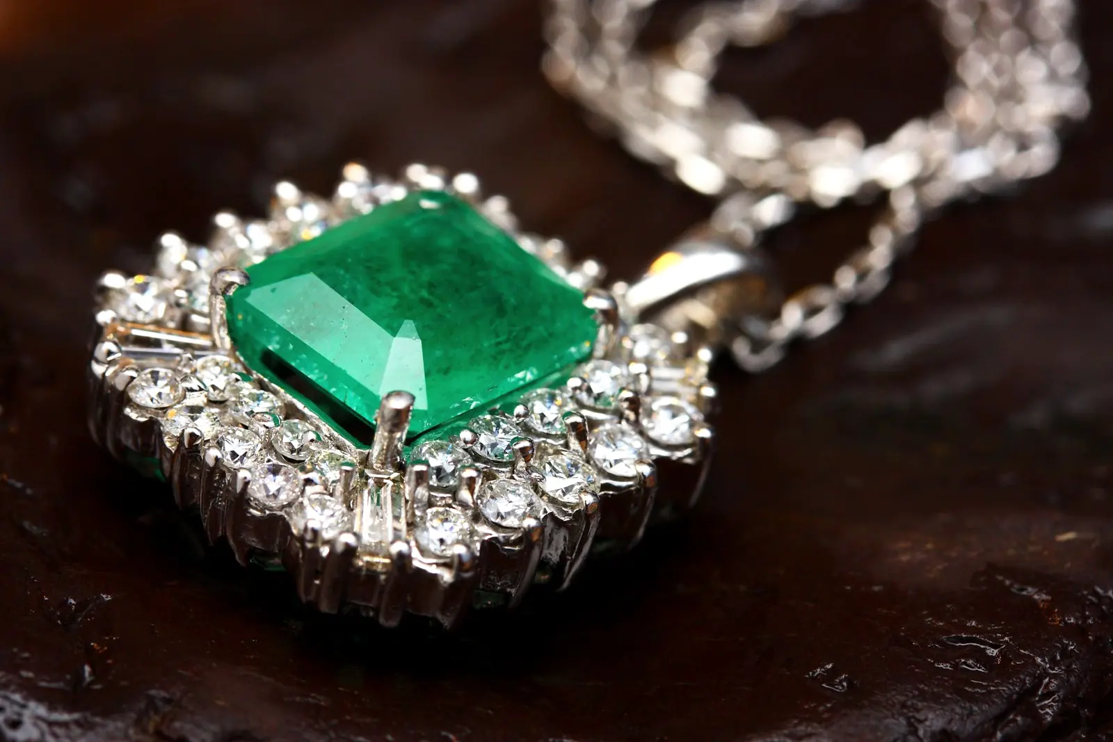 Colgante de plata con una esmeralda rodeada de pequeñas piedras